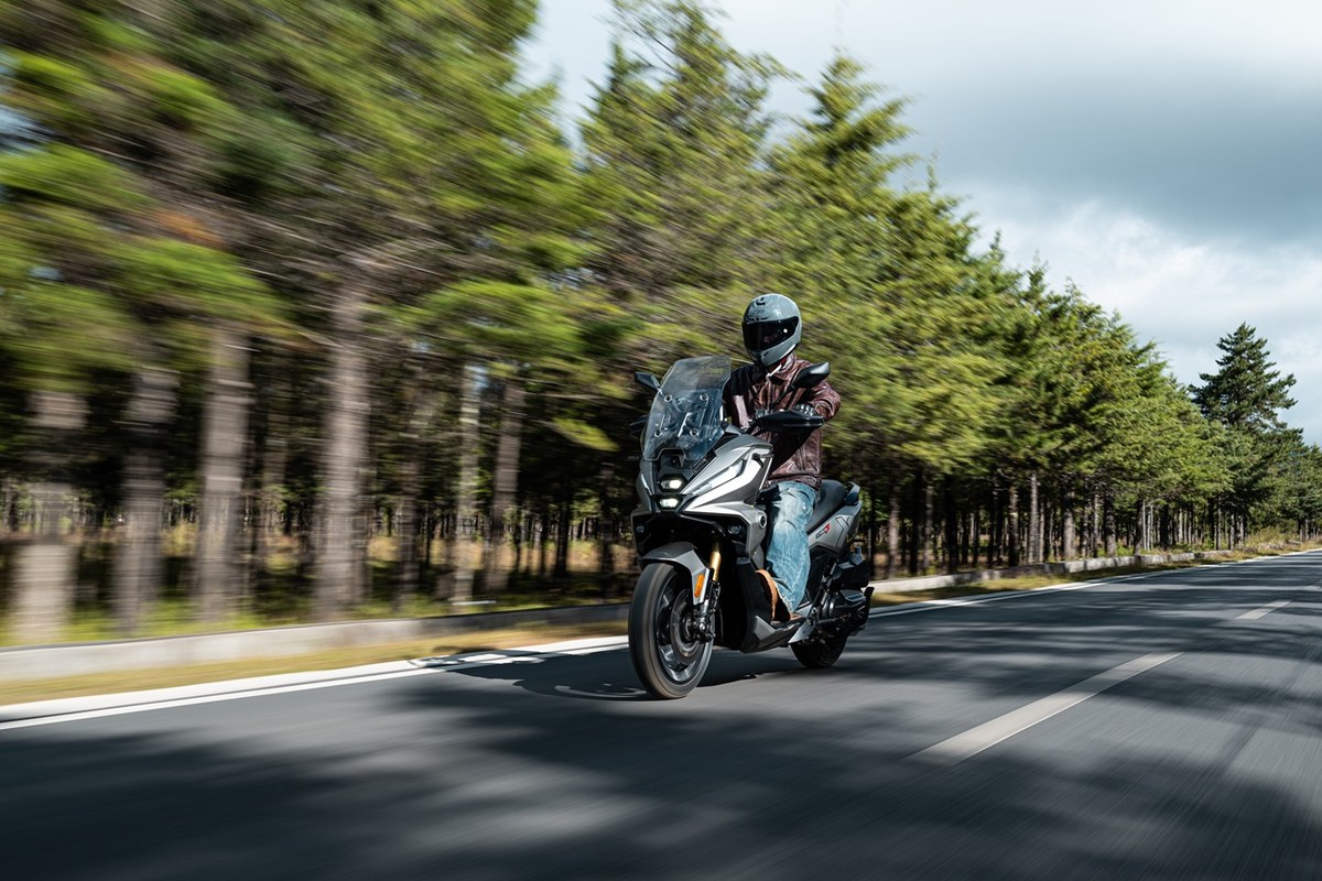 רוכב על קטנוע VOGE SR450X בנסיעה על כביש בין שדרות עצים