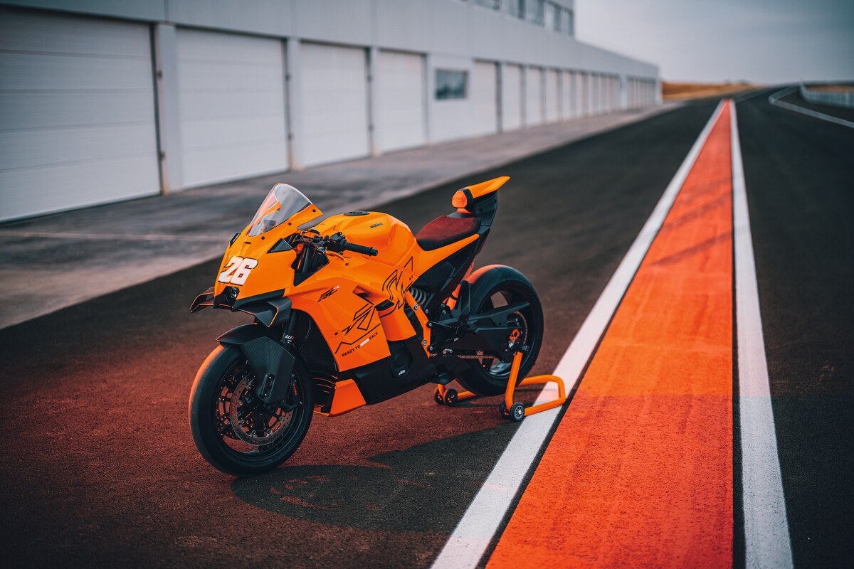 אופנוע KTM 990 RC R בצבע כתום בצילום סטטי מצד שמאל, ניצב בנתיב הפיטים של מסלול מרוצים