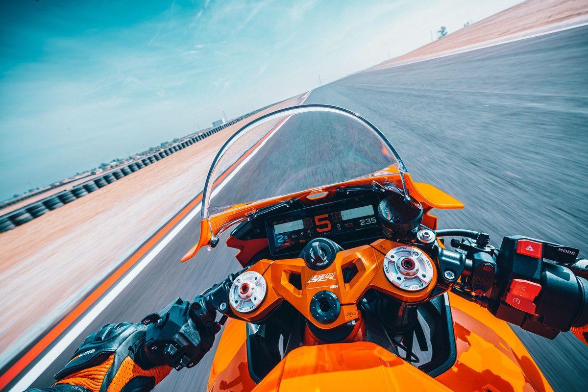 מבט מנקודת מבטו של הרוכב על מסך ה-TFT האופקי של KTM 990 RC R בזמן נסיעה על מסלול